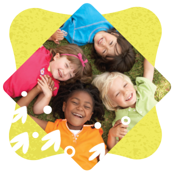 Closeup of four smiling children lying on their backs with heads touching and holding hands